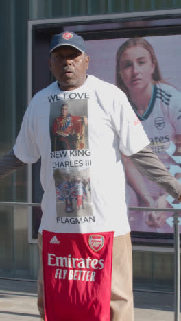 Vertical-Video-Of-Fan-Dancing-Outside-The-Emirates-Stadium-Home-Ground-Arsenal-Football-Club-London-On-Match-Day